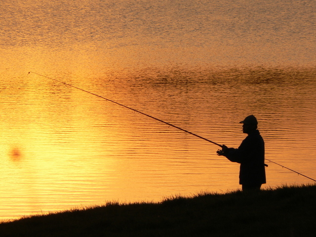 rybář při západu slunce u jezera